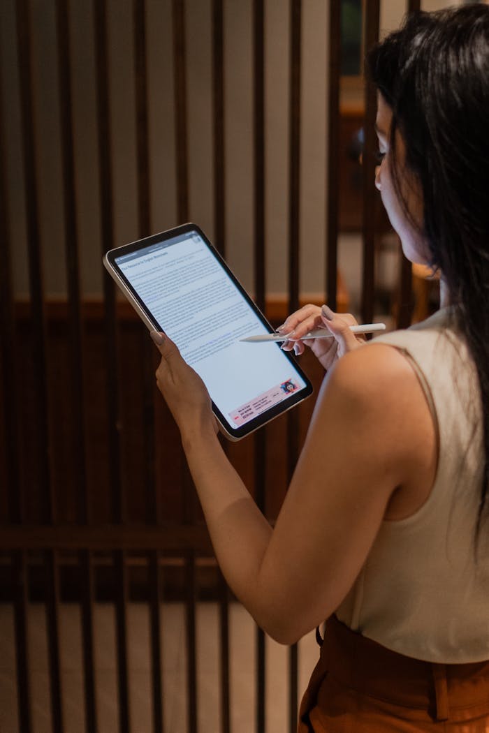 Professional woman analyzing a document on a digital tablet in a modern office setting.